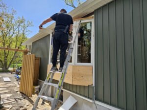 Installer working on window replacement (exterior view)